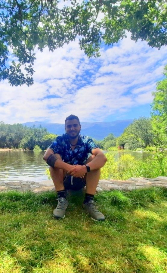 Luis sentado junto a un lago
